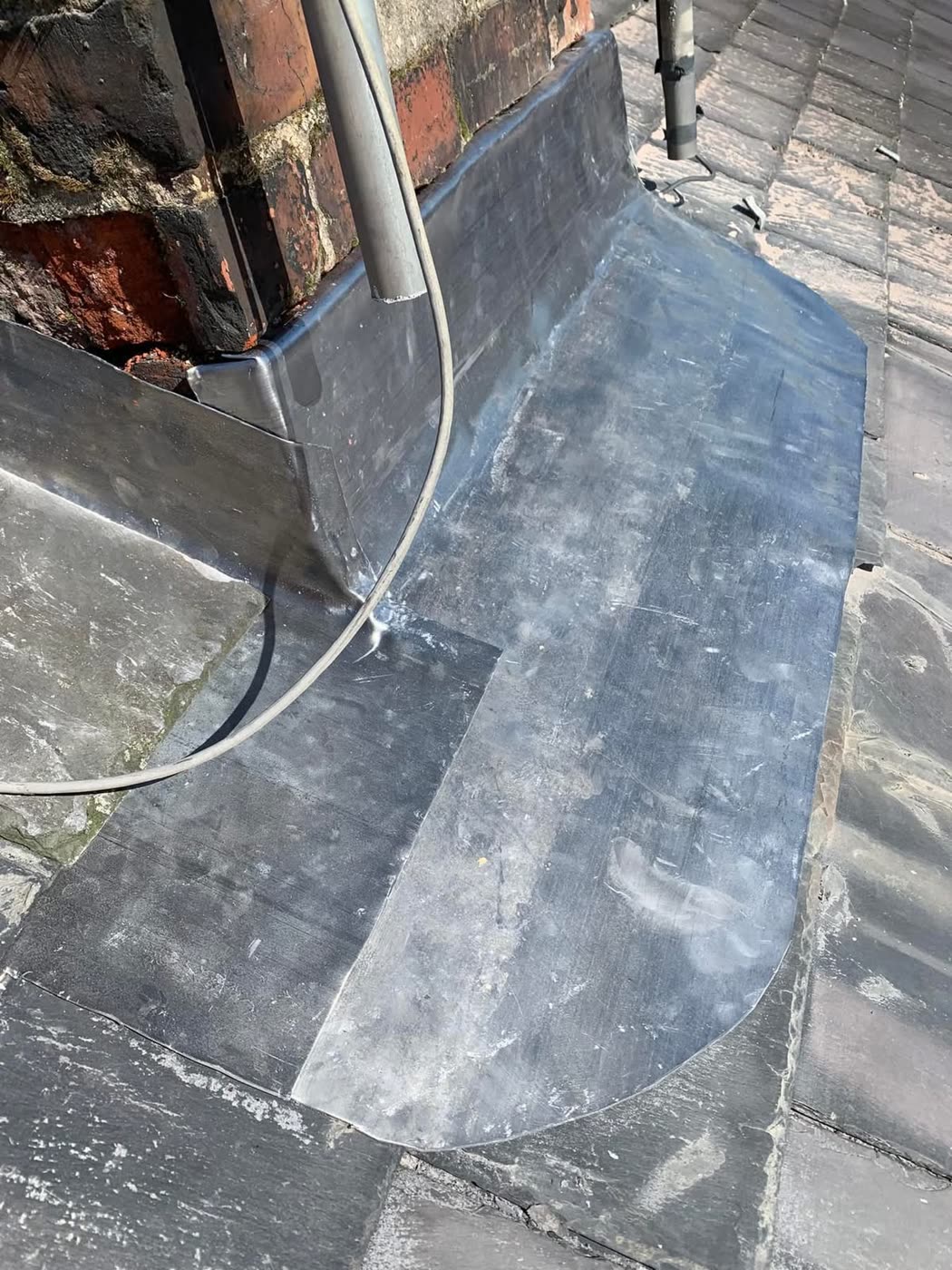 Leadwork apron flashing detail beside a chimney